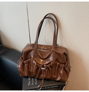 Détail des plis du sac fourre-tout marron vintage avec texture en cuir brillant