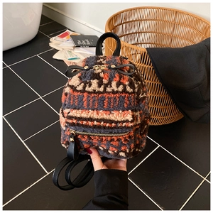 Detailansicht des Plüschrucksacks mit bunten geometrischen Mustern und Metallreißverschluss