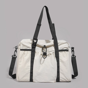 Detail view of large nylon travel tote with drawstring pocket and black buckle fastener