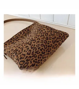 Vista dettagliata della trama del tessuto leopardato e delle cuciture della borsa marrone