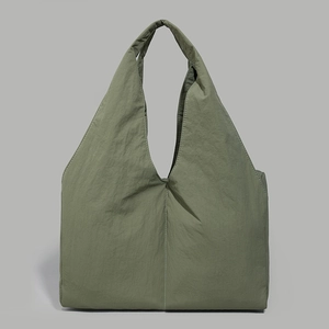 Detailed texture of army green nylon tote bag with wide strap and vertical stitching
