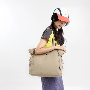 Detail of khaki large tote bag with drawstring closure and button on casual model