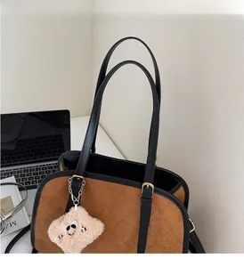 Détail du cabas matelassé marron avec texture douce et élégant accessoire en peluche