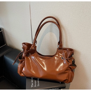 Détail du sac cabas en cuir verni marron caramel avec design à cordon de serrage