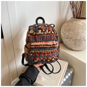 Detail eines Fleece-Minirucksacks mit geometrischen Mustern und goldenem Reißverschluss