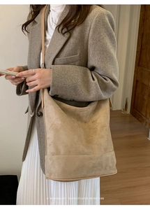 Detail of minimalist beige suede bucket bag texture shown on shoulder for daily commute