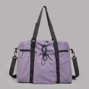 Macro view of lilac waterproof nylon fabric and reinforced black straps on tote bag