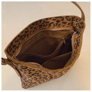 Dettaglio interno della borsa leopardata con fodera marrone e tasca con zip
