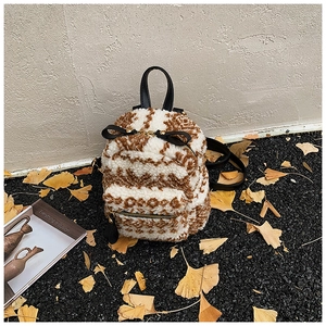 Detailansicht eines Mini-Plüschrucksacks mit geometrischem Muster und Lederbesatz