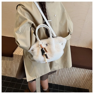 Detail der weißen Kunstfell-Handtasche mit Lederriemen und dekorativen Holzperlen