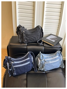 Three denim crossbody bags in grey, dark blue and light blue with multi-zipper detail