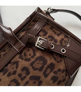 Détail du sac léopard avec boucle argentée et garniture en cuir marron foncé rétro