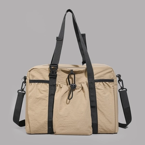 Detail of khaki large capacity travel tote bag featuring front drawstring pocket and straps