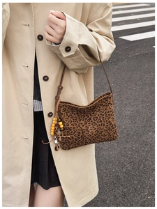 Dettaglio borsa a tracolla leopardata con nappa decorativa in perline etniche