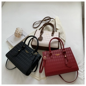 Three quilted crossbody bags in black, burgundy and beige displayed on white fabric