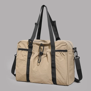 Detailed view of khaki travel tote featuring durable nylon texture and black woven straps