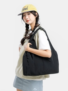 Minimalist large black nylon tote bag shown on model for casual urban shoulder wear