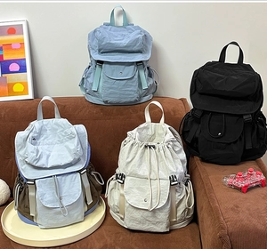 Vista dettagliata di zaini casual in nylon nei colori azzurro, grigio blu, beige e nero