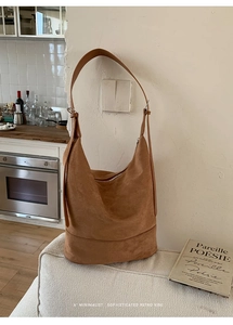 Minimalist large-capacity retro camel suede hobo bag hanging in a home setting
