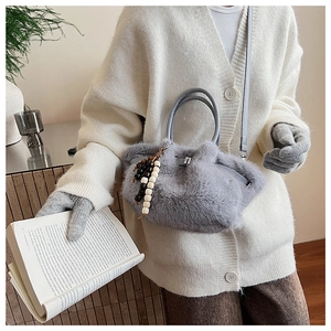 Detail der grauen Plüsch-Handtasche aus Kunstpelz mit Ledergriff und Zierperlen