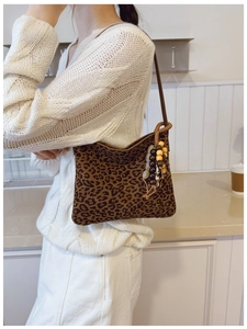 Dettaglio borsa a spalla leopardata con nappa decorativa in perline e tracolla marrone