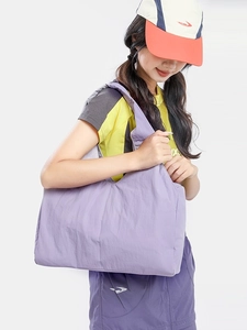 Purple pleated nylon large capacity shoulder bag for women worn by a model in casual style