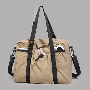 Detail showing khaki multi-pocket travel tote with water-resistant nylon and crossbody strap
