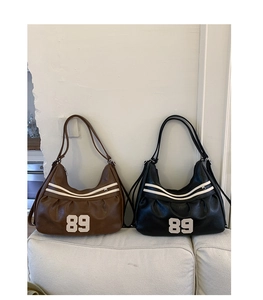 Dettaglio borse hobo vintage in nero e marrone con ricamo del numero 89 sul fronte