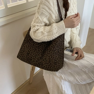 Detail van vintage tote bag met luipaardprint en bruine leren riemen in een lifestyle setting
