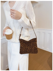 Borsa a spalla leopardata alla moda indossata da una modella in un interno luminoso