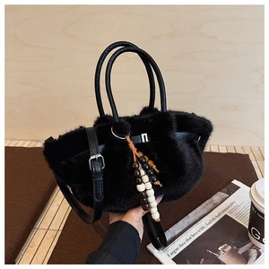 Detail der schwarzen Plüschtasche mit Holzperlen-Anhänger und Lederriemen für Damen