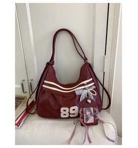 Dettaglio dello zaino vintage bordeaux con stampa 89 e ciondolo di pizzo e perle
