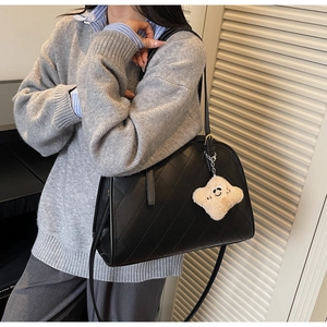 Détail du sac cabas matelassé noir avec un charmant pendentif nuage en peluche douce