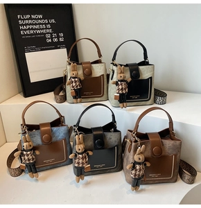 Detail view of five stylish PU leather bucket bags in various colors with plaid rabbit charms
