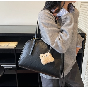 Détail du sac cabas matelassé noir avec boucles dorées et breloque étoile en peluche