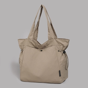 Detail view of khaki minimalist tote bag showing side drawstring and fabric texture