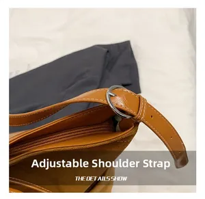 Detail showing the adjustable shoulder strap and silver metal buckle on brown tote bag