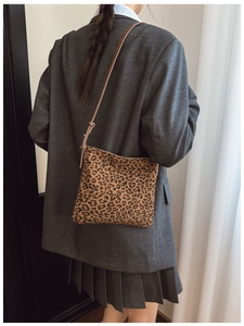 Vista posteriore di una modella con la borsa a tracolla leopardata e cinturino marrone