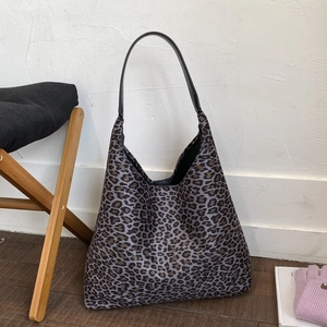 Detailopname van de grote luipaardprint shopper tas met zwarte leren handvaten in huis