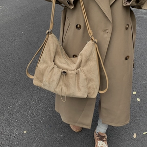 Detalle del bolso tote de ante caqui con bolsillo de cordón en modelo de calle