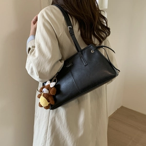 Dettaglio borsa tote in ecopelle nera con cordoncino metallico e ciondolo orsetto