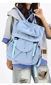 Dettaglio zaino casual azzurro con tasche multiple, fibbia in metallo e coulisse laterali