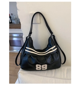 Dettaglio della texture in pelle PU nera pieghettata con strisce bianche e numero 89