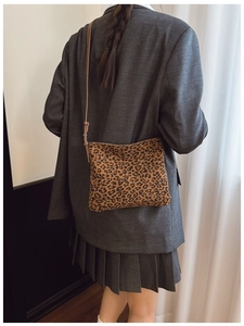 Dettaglio della borsa a spalla leopardata indossata con un blazer grigio in stile moderno