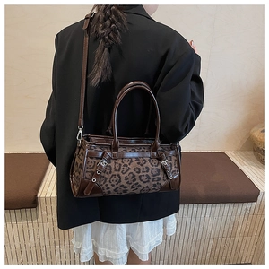 Detail der Handtasche mit Leopardenmuster, braunem Lederbesatz und Schultergurt