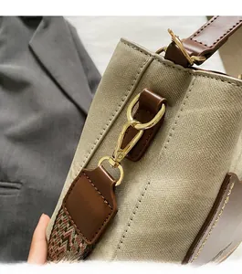 Detailed close-up of golden metal hooks and woven ethnic pattern strap on canvas tote