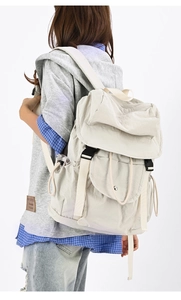 Dettaglio dello zaino beige in nylon impermeabile con lacci e chiusure a fibbia in plastica