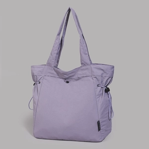 Detail of lavender nylon tote bag featuring adjustable drawstring and metal snap button