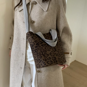 Detailed view of the leopard print bucket bag with high-quality woven shoulder strap