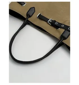 Detail der khakifarbenen Canvas-Tasche mit schwarzen Lederriemen und Silberschnallen